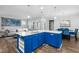 Bright, open kitchen with island featuring blue cabinets, quartz countertops, and modern appliances at 5520 Advancing Ave, Raleigh, NC 27616