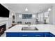 Open-concept kitchen with a large island, quartz countertop, stainless sink and modern fixtures at 5520 Advancing Ave, Raleigh, NC 27616
