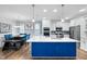 Open-concept kitchen with large island featuring blue cabinets, quartz countertops, and stainless appliances at 5520 Advancing Ave, Raleigh, NC 27616
