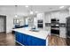 Bright, open kitchen featuring a large blue island, quartz counters and stainless steel appliances at 5520 Advancing Ave, Raleigh, NC 27616