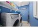 Bright laundry room featuring a modern washer and dryer with ample shelving for storage and blue walls at 5520 Advancing Ave, Raleigh, NC 27616
