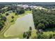 Picturesque aerial view of a serene lake surrounded by lush trees and a community park nearby at 5708 Creekfall Ln, Fuquay Varina, NC 27526