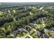 Aerial view of homes in a wooded community setting, with well-manicured lawns and mature trees at 5708 Creekfall Ln, Fuquay Varina, NC 27526