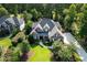 Aerial shot of a beautifully landscaped brick home featuring a manicured lawn and mature trees at 5708 Creekfall Ln, Fuquay Varina, NC 27526