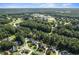 Wide aerial view of property and surrounding area with lake and school in distance at 5708 Creekfall Ln, Fuquay Varina, NC 27526