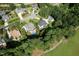 Expansive aerial view of a lovely neighborhood with mature trees, manicured lawns, and sparkling pool at 5708 Creekfall Ln, Fuquay Varina, NC 27526