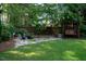 Serene backyard featuring a rock waterfall, swing, and lush landscaping at 5708 Creekfall Ln, Fuquay Varina, NC 27526