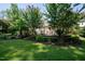 Serene backyard featuring a stone patio, pergola, lush landscaping, and manicured lawn at 5708 Creekfall Ln, Fuquay Varina, NC 27526