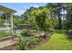 Manicured backyard with mature landscaping, a pool, and dining area at 5708 Creekfall Ln, Fuquay Varina, NC 27526