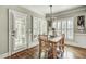 Dining area features hardwood floors, white trim, a wooden table and natural light at 5708 Creekfall Ln, Fuquay Varina, NC 27526