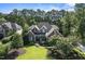 Aerial view of brick home boasting a manicured lawn, mature trees and lush landscaping at 5708 Creekfall Ln, Fuquay Varina, NC 27526