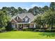 Charming brick home with manicured lawn, mature trees, and lush landscaping at 5708 Creekfall Ln, Fuquay Varina, NC 27526