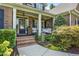 Charming front porch with swing, seating and brick steps leading to the front door at 5708 Creekfall Ln, Fuquay Varina, NC 27526