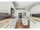 Well-lit kitchen boasts an island, gas cooktop, modern appliances and granite counters at 5708 Creekfall Ln, Fuquay Varina, NC 27526