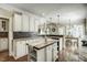 Open kitchen with an island, white cabinets, dining area, and stainless steel appliances at 5708 Creekfall Ln, Fuquay Varina, NC 27526