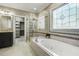 Luxurious main bathroom featuring a soaking tub and a glass-enclosed shower at 5708 Creekfall Ln, Fuquay Varina, NC 27526