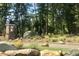 Community entrance featuring a stone monument with the community name, mature trees, and landscaping at 59 Riverstone Dr, Pittsboro, NC 27312