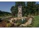 A stone monument at the entrance with landscaping, boulders, and a water feature with fountains at 59 Riverstone Dr, Pittsboro, NC 27312