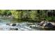Scenic river view featuring lush green trees and rugged rock formations along the water's edge at 59 Riverstone Dr, Pittsboro, NC 27312