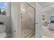 Shower with glass doors, neutral tile, and window for light in bathroom with access to bedroom at 60 Pintail Lane Ln, Youngsville, NC 27596