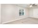 Bedroom featuring neutral carpeting, a ceiling fan, light gray walls, and a large window with a view of the outdoors at 60 Pintail Lane Ln, Youngsville, NC 27596