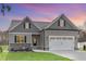 Charming gray home with a two-car garage, gray roof, and manicured lawn and professional landscaping at 60 Pintail Lane Ln, Youngsville, NC 27596
