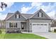 Charming gray home with a two-car garage, gray roof, and manicured lawn and professional landscaping at 60 Pintail Lane Ln, Youngsville, NC 27596