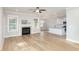 Bright living room with fireplace, ceiling fan, wood floors, and open floor plan to the kitchen at 60 Pintail Lane Ln, Youngsville, NC 27596
