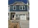 New two-story townhome featuring attached garage, stone accents, neutral siding, and a white front door at 62 Shay St, Angier, NC 27501