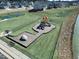 A community playground with multiple slides and play features, adjacent to pond and homes at 669 Impala Trce, Wendell, NC 27591