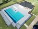 Aerial view of a community pool with ample deck space, shaded seating, and manicured lawn at 669 Impala Trce, Wendell, NC 27591