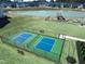 Aerial view of a well maintained tennis court inside of a black chain link fence at 669 Impala Trce, Wendell, NC 27591