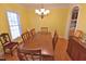 Bright dining room featuring a large wood table, elegant chandelier, and hardwood floors at 730 Duck Pond Rd, Nashville, NC 27856