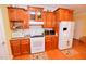 Well-lit kitchen showcasing wood cabinets, granite countertops, and white appliances at 730 Duck Pond Rd, Nashville, NC 27856