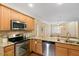 Kitchen showcasing granite counters, wooden cabinets, and open layout connecting to the living space at 968 Shoofly Path, Apex, NC 27502