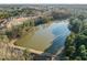 Scenic aerial view of a serene lake surrounded by lush trees and a quaint neighborhood at 1027 Laurelwood Dr, Durham, NC 27705