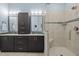 Modern bathroom featuring dual vanities, dark cabinetry, and a glass-enclosed shower with a built-in seat at 1027 Laurelwood Dr, Durham, NC 27705