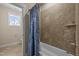 Full bathroom showcasing tile surround tub/shower combo with curtain and neutral walls at 1027 Laurelwood Dr, Durham, NC 27705