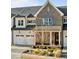 Charming townhome showcasing a beautiful brick and siding facade, complemented by an attached two-car garage and manicured landscaping at 1027 Laurelwood Dr, Durham, NC 27705