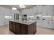 Modern kitchen boasts white cabinets, granite counters, stainless appliances, and a large center island at 1027 Laurelwood Dr, Durham, NC 27705