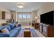 Living room with large tv, blue sofa, wood floors and a large window at 1027 Laurelwood Dr, Durham, NC 27705