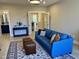 Open-concept living space with a blue couch, decorative rug and light colored wood flooring at 1027 Laurelwood Dr, Durham, NC 27705