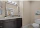 Stylish powder room with granite countertop, dark wood cabinets, and toilet at 1027 Laurelwood Dr, Durham, NC 27705