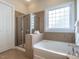 Bright bathroom featuring a soaking tub and a glass-enclosed shower at 1028 Dotson Way, Apex, NC 27523
