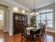 Elegant dining room featuring hardwood floors, a large window, and a stylish chandelier at 1028 Dotson Way, Apex, NC 27523