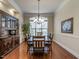 Dining room with a large arched window for natural light, a dark wood china cabinet and a chandelier at 1028 Dotson Way, Apex, NC 27523