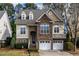 Charming two-story home featuring a stone facade, two-car garage, and manicured landscaping at 1028 Dotson Way, Apex, NC 27523