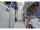 View of the garage with storage shelves, tool pegboard, workbench, and a white refrigerator at 1028 Dotson Way, Apex, NC 27523