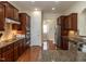 Spacious kitchen featuring hardwood floors, stainless steel appliances, granite countertops, and dark wood cabinetry at 1028 Dotson Way, Apex, NC 27523