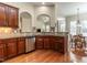 Kitchen with stainless steel dishwasher, granite countertops, dark wood cabinets, and hardwood floors at 1028 Dotson Way, Apex, NC 27523